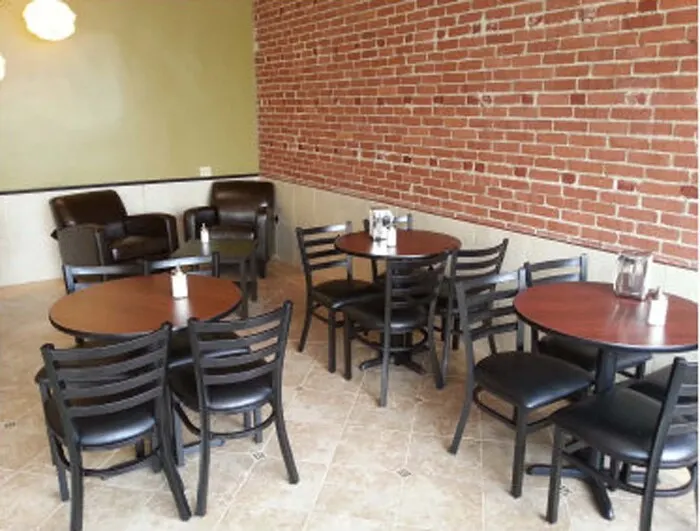 Café tables by a brick wall