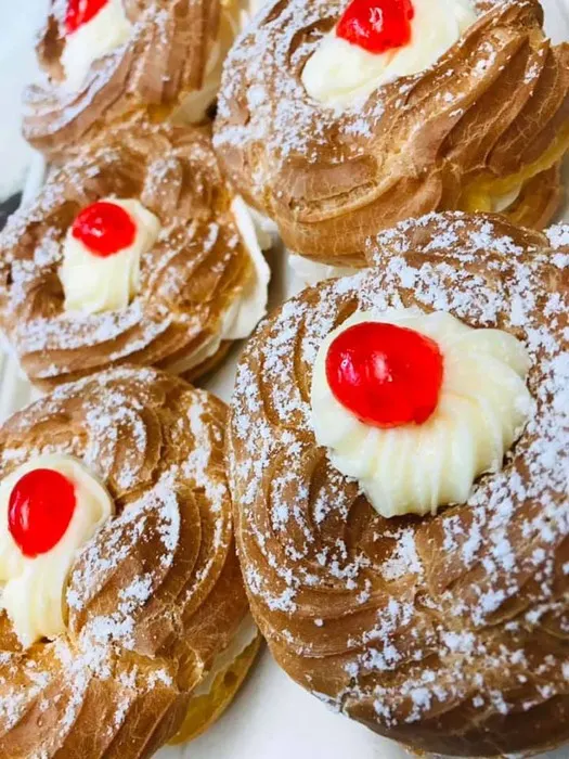 Cream-filled pastries topped with cherries